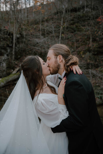 photo of bride and groom kissing after their wedding ceremony