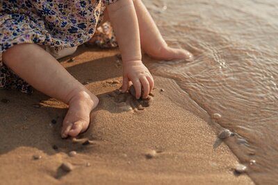 Parent walking with toddler by the lake photographed through Michigan photography