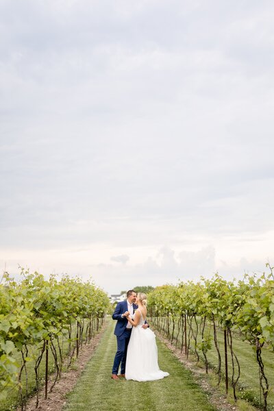 Bride and groom sit laughing in the back of their wedding kombi van at cave springs winery
