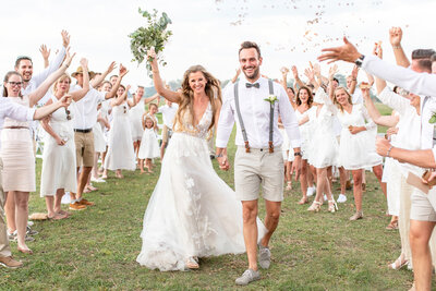 Couple lifting bouquet and walking back down the aisle
