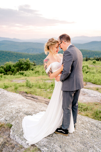 Couple on a summit holding each other after their vows. Captured by their New England Elopement Photographer