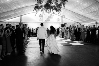 black and white of bride and groom entering reception greeted by guests at Glen Foerd Estate in Philadelphia, PA