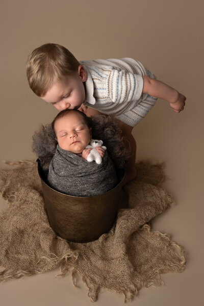 Big brother meeting newborn baby bucket pose Cedar Park family photographer
