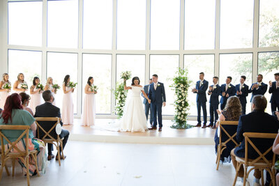 Austin-based wedding photographer captures a stunning wedding ceremony filled with natural light streaming through large windows.