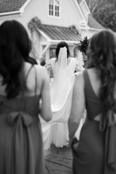 A bride walking in front of two bridesmaids