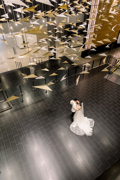 bride and groom dancing under paper airplanes at chicago old post office