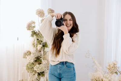 A wedding photographer posing for the camera.