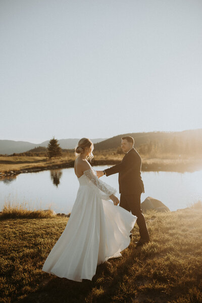 sunset photo of bride and groom dancing in front of lake in montana