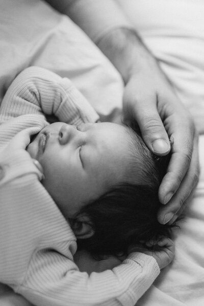 A peaceful black and white photo capturing the innocence of a sleeping baby in a newborn photoshoot