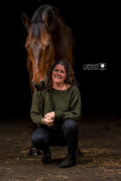 Bruin paard met eigenaar, zwarte achtergrond