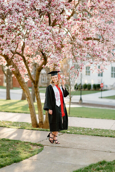 senior wearing graduation gown posing for nashville senior photographer