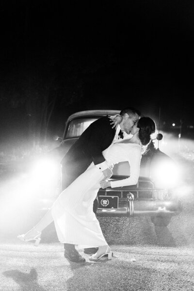 Ohio bride and groom posing near their getaway car following their tented Ohio wedding in Akron, Ohio