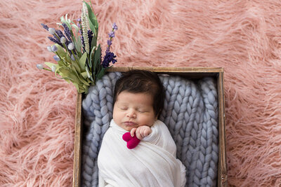 Newborn baby girl in a wooden crate