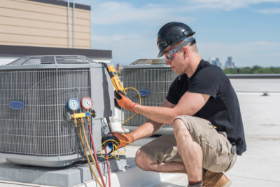 Image of an HVAC technician monitoring the output levels of a rooftop unit