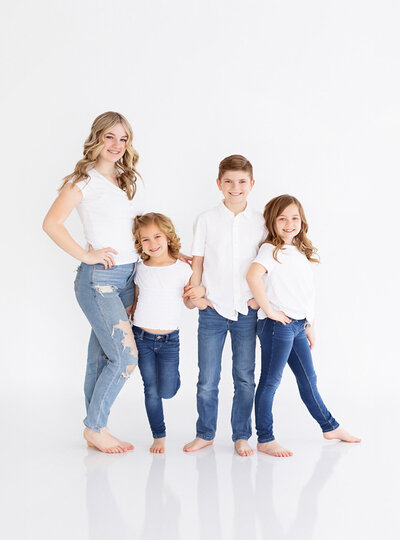 4 siblings standing together at Boise portrait studio.