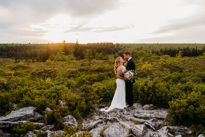 Eloping couple standing together on a rocky mountain overlook at sunset in Dolly Sods, West Virginia