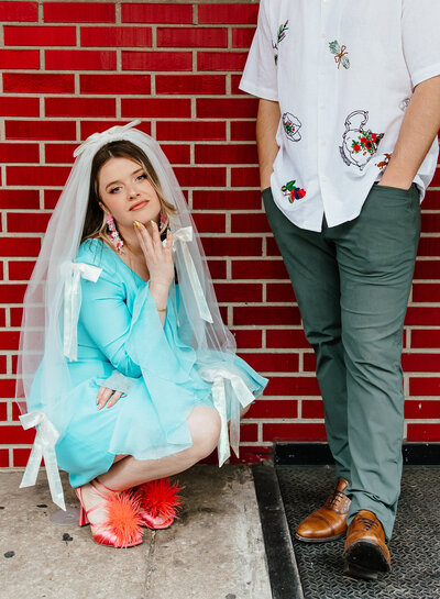 Bride & groom kissing while seated on rock