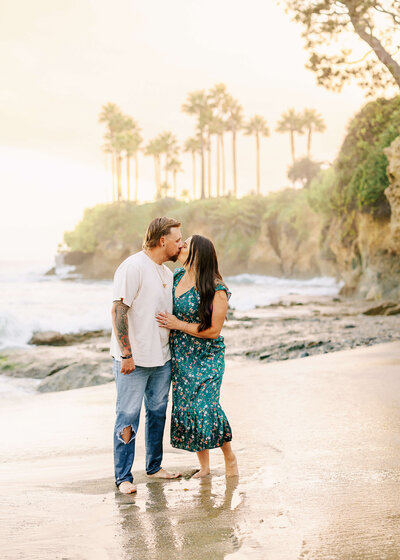 Couple kissing on beach during family photos