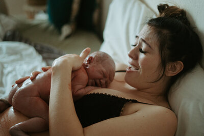 woman holding newborn on chest