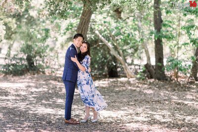 Engaged couple embrace as they pose for engagement photos at the O'Neill Regional Park in Trabuco Canyon
