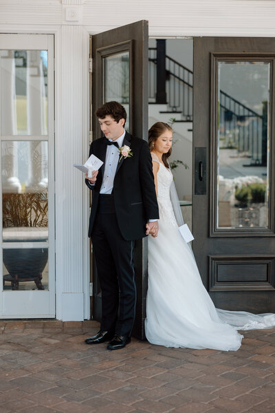 Bride holds bouquet and looks at the groom as they go in for a kiss.