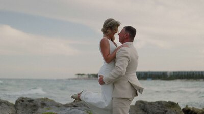 Couple posing against a golden-hour Isla Mujeres sunset.