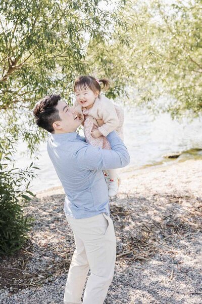 Candid family portrait by a Toronto newborn and portrait photographer, showcasing a playful parent-child moment