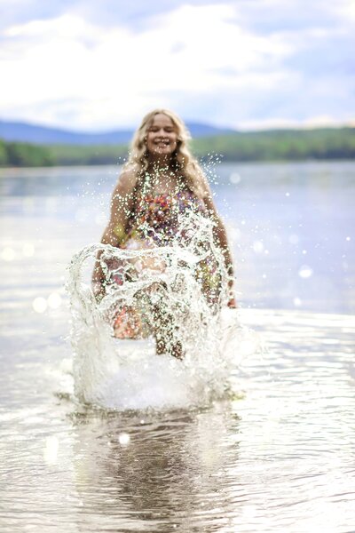 Photo of girl kicking up water  | Senior Session