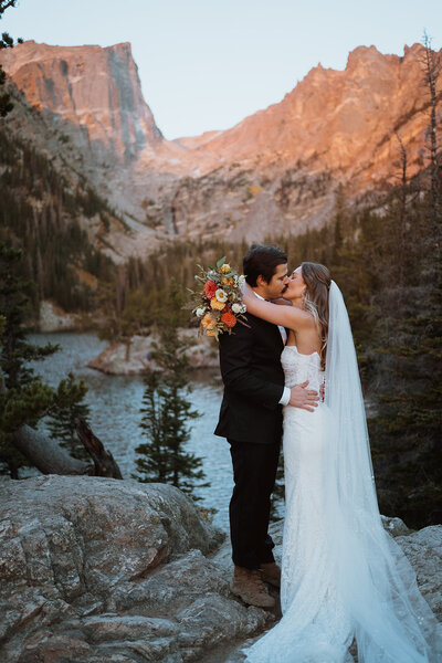 couple hugging at their Colorado elopement in front of the mountains. They eloped in Breckenridge colorado on the top of a mountain where they said their vows and celebrated with family and friends. Plan your Breckenridge elopement with me and we will find the best and most secluded mountain elopement locations in Colorado!
