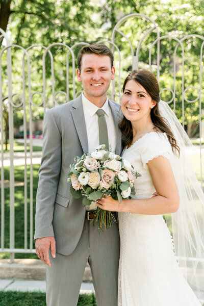 groom sitting next to bride holding bright and beautiful bouquet made by Buds Blooms and Blossoms