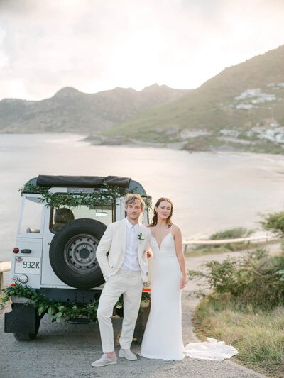 Stylish couple sharing a kiss beside a Land Rover under soft evening light in St Barth — Destination Wedding Photographer Portfolio.