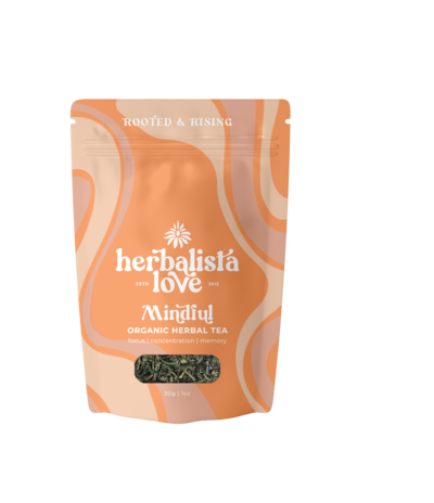 A pouch of Herbalista Love Nourish herbal tea displayed against a peach-colored background. The packaging features wavy, abstract patterns in soft pink and beige, surrounding the brand name. A transparent window at the bottom reveals the loose tea inside. The design reflects a warm, nourishing theme, aligning with the product's focus on wellness and holistic care.