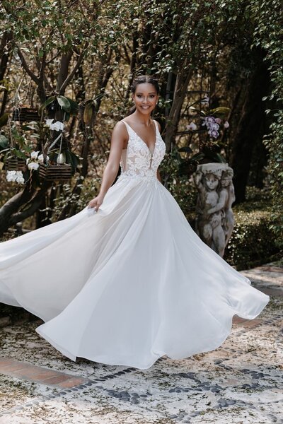 The smooth overlay of this gown's full skirt is a beautiful contrast to the soft, dimensional appliques along the bodice.