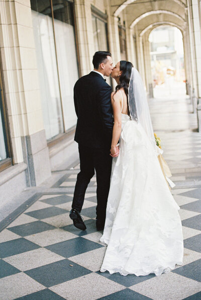 couple kissing by Hudsons Bay Building in Calgary