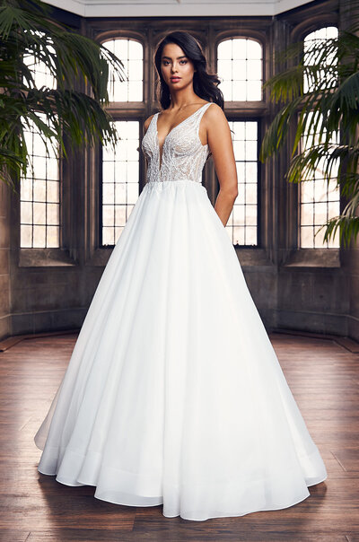 Paloma Satin and Guipure Lace Wedding Dress. Sleeveless Paloma Satin gown with bateau neckline. Guipure Lace at shoulders and armholes, continuing on to illusion lace back. Fabric belt along front of gown. Fit and flare satin skirt. Available Colours: Natural.