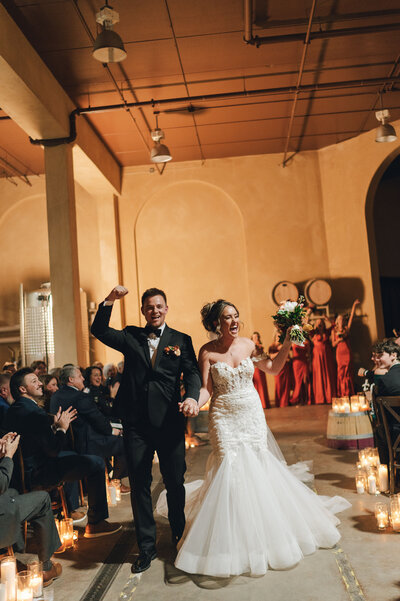 Newly married couple walking back down the aisle after saying I do