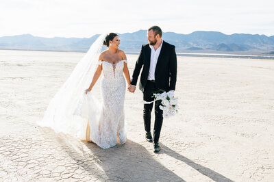 wedding couple walks across desert