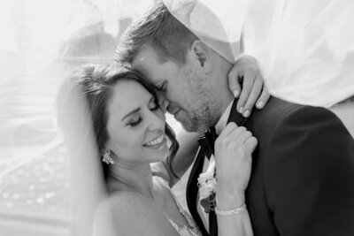 Bride and groom embrace under bride's veil