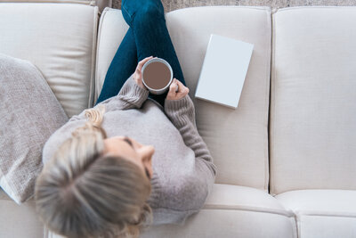 Dr. Tracy sitting on the couch with a book