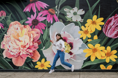 Photo of Eliana Melmed Photography jumping in front of Chicago Mural