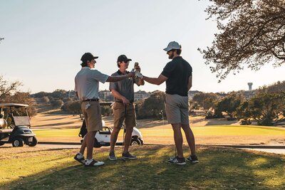 Corporate event charity golf outing with men toasting with beers