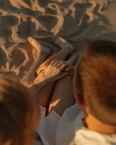 couple holding hands on beach in pei for lifestyle photos