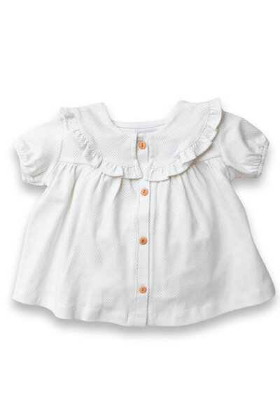A white and sage green dot top with ruffled color and sleeves and buttons for little girls back to school