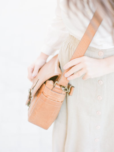 A person holding a crossbody bag.