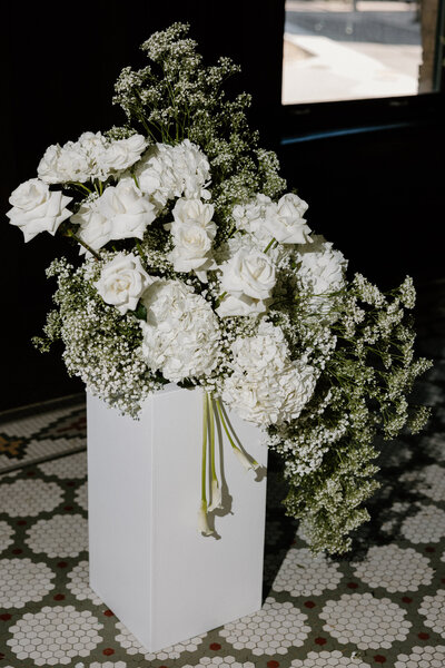 A bouquet of white flowers in a white vase 