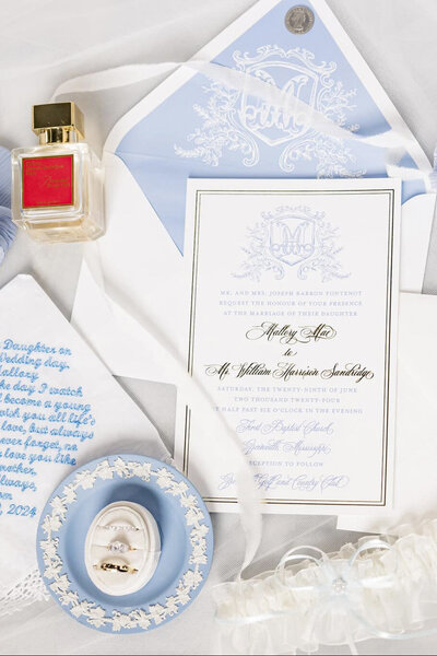 Wedding invitation suite with dusty blues and gold ink with an intricate monogram.