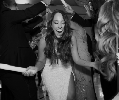 Unfiltered wedding celebration moment with the bride surrounded by friends and energy
