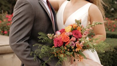 Husband and wife hold each other with custom florals