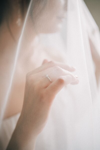 A bride pushing out her veil from her face.