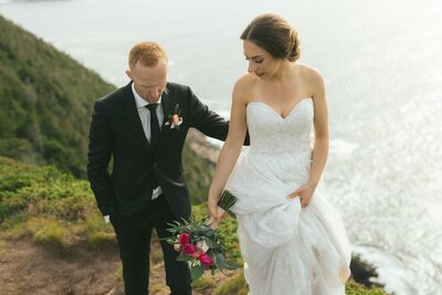 bride and groom explore a sea cliff in Newfoundland